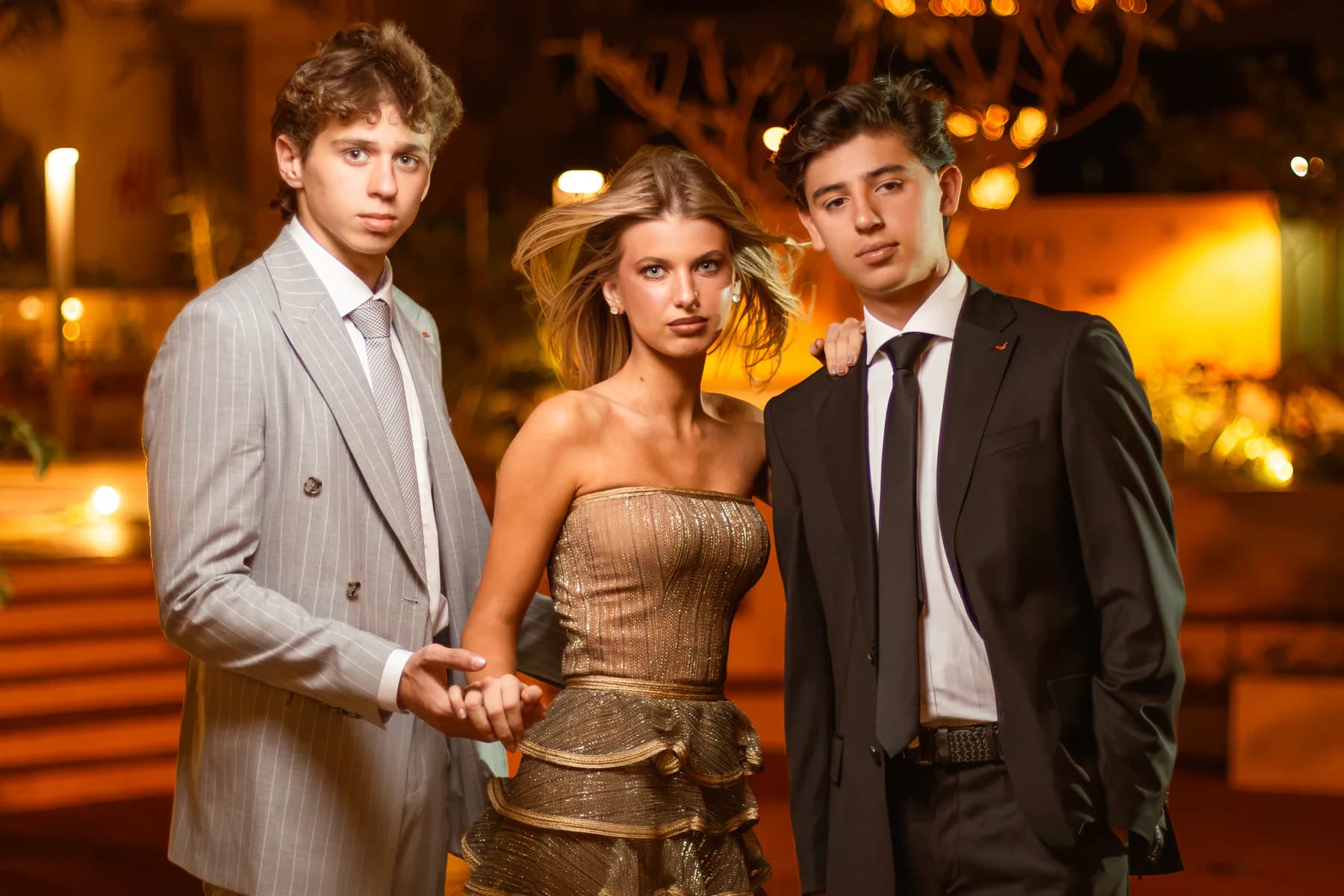 Tres modelos con estilismo formal bajo iluminación nocturna